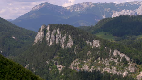 train passing on train tracks running on high cliffs in stunning nature landscape