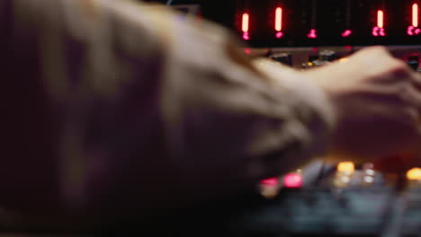 audio technician uses mixing console and faders in control room