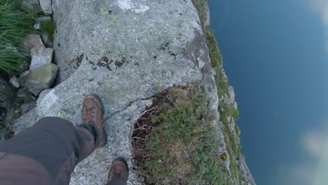 daredevil walking near a 600-meter drop next to pulpit rock, norway