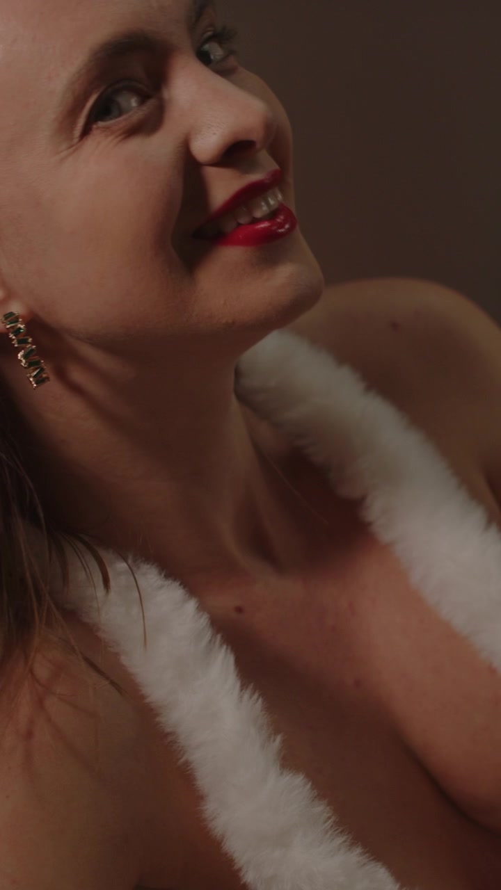 Beautiful vertical portrait of an attractive woman wearing fake fur clothing smiling and laughing in slow motion