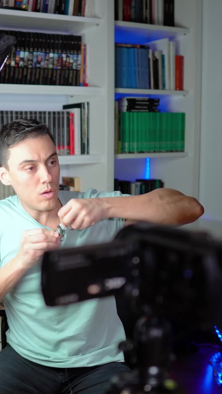 Man in front of a camera and bookshelf