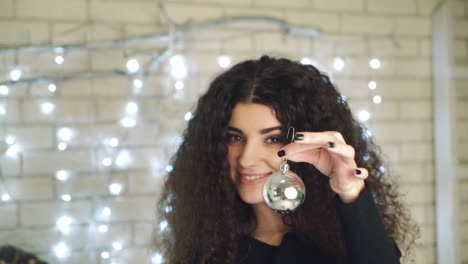 girl holding christmas toy. young woman holding toy for decorating christmas tree at home