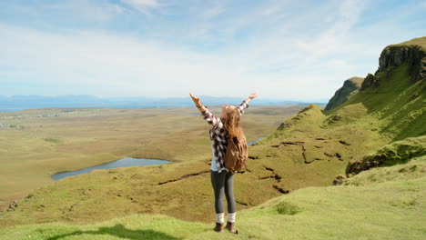 woman enjoying a scenic view from a mountaintop in scotland