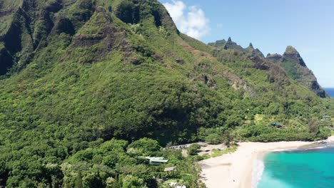 aerial wide reverse pullback shot of the maniniholo dry cave in haena on the island of kaua'i, hawai'i