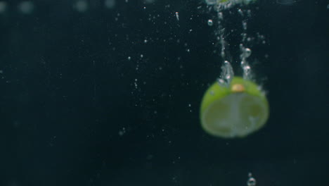lime dropped in water slow motion.