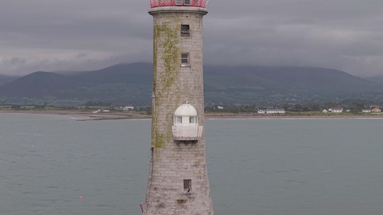 Haulbowline Lighthouse by the sea under a cloudy sky in Northern Ireland