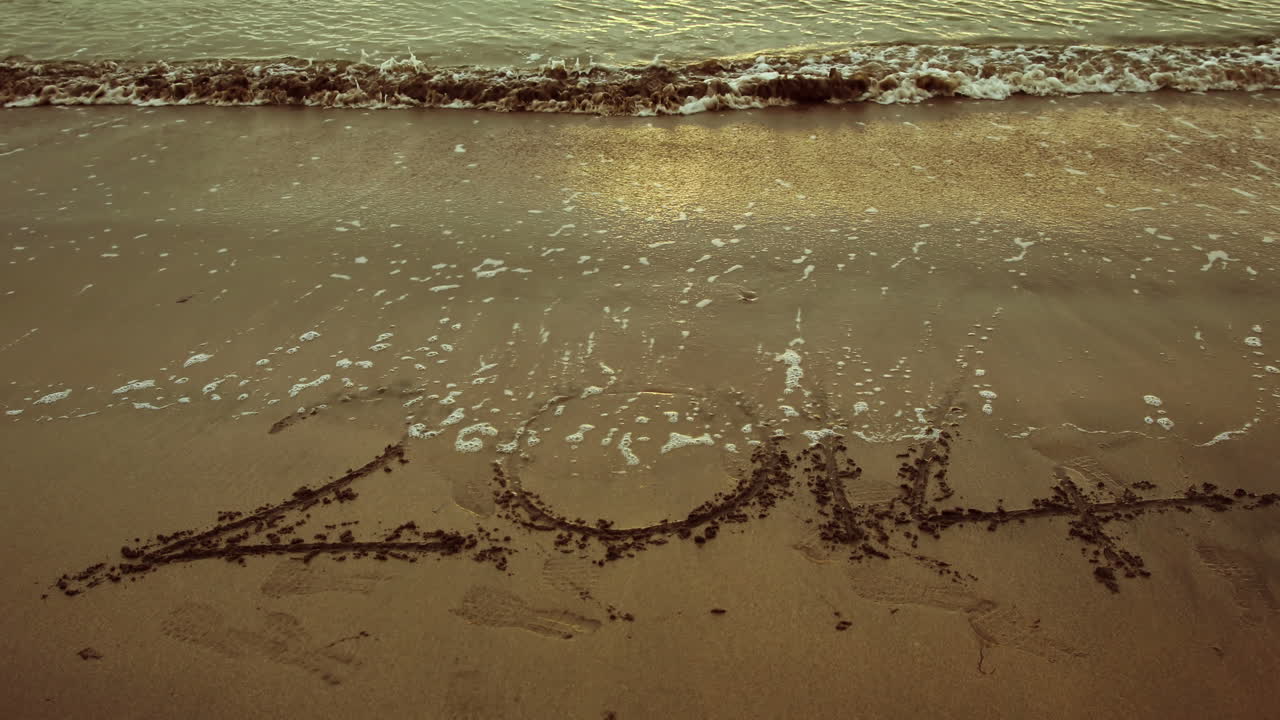 물결이 모래에서 2014을 돌고 있습니다.