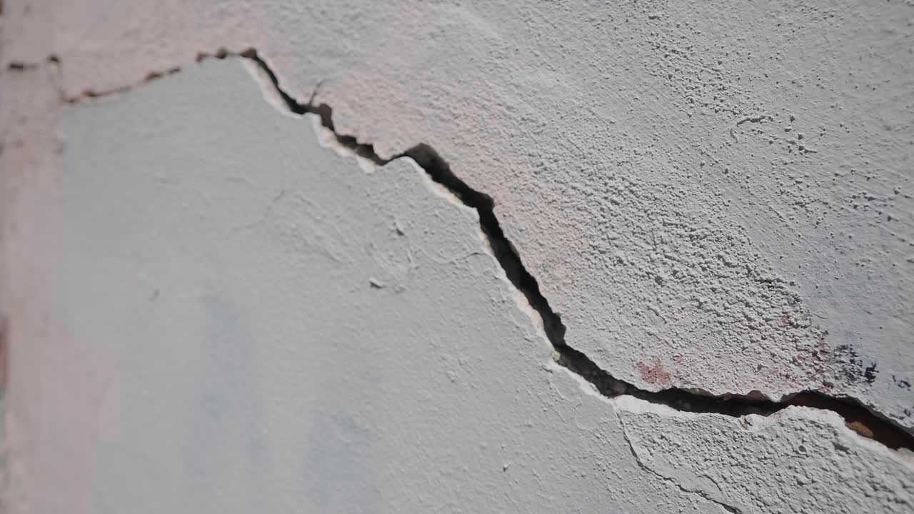 Close Up of a Large Crack in a Grey Concrete Wall
