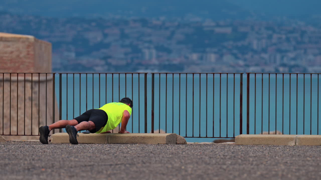 Man working out near the sea in Antibes, France with the city and the mountains on the background