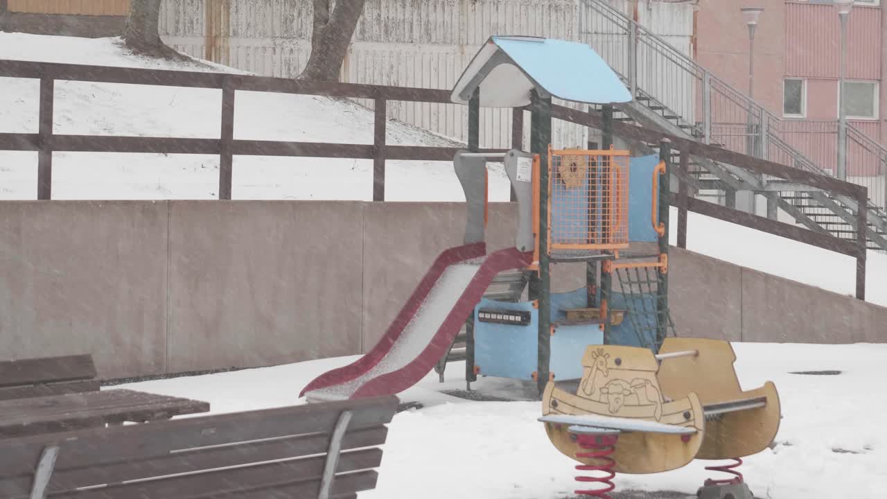 추운 겨울 날에 많은 눈이 내리는 동안 황폐한 놀이터의 정적  ⁇