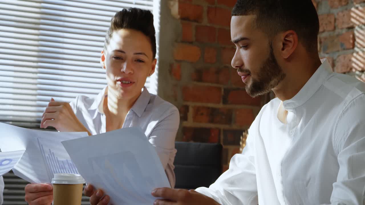 Executives discussing over document in office 4k