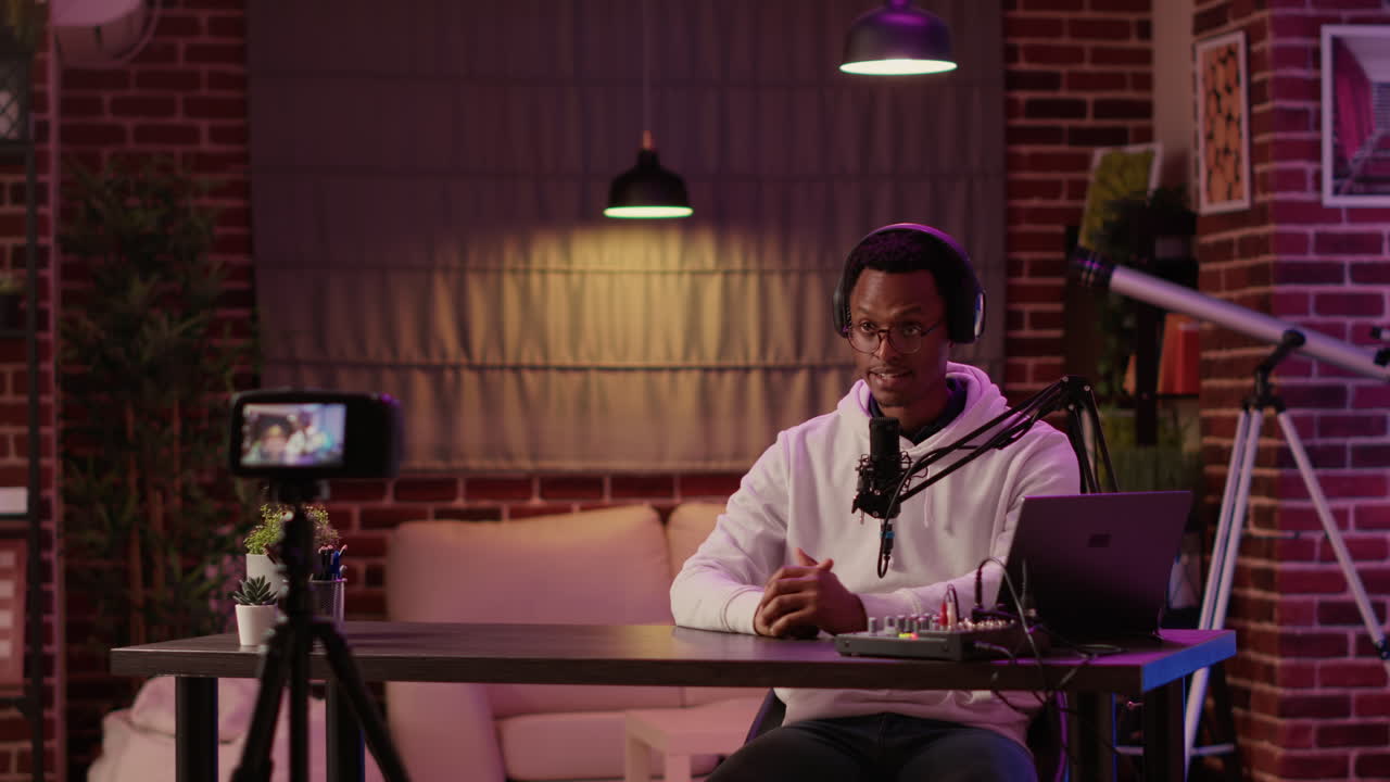 African american content creator recording podcast using digital video camera for social media vlog