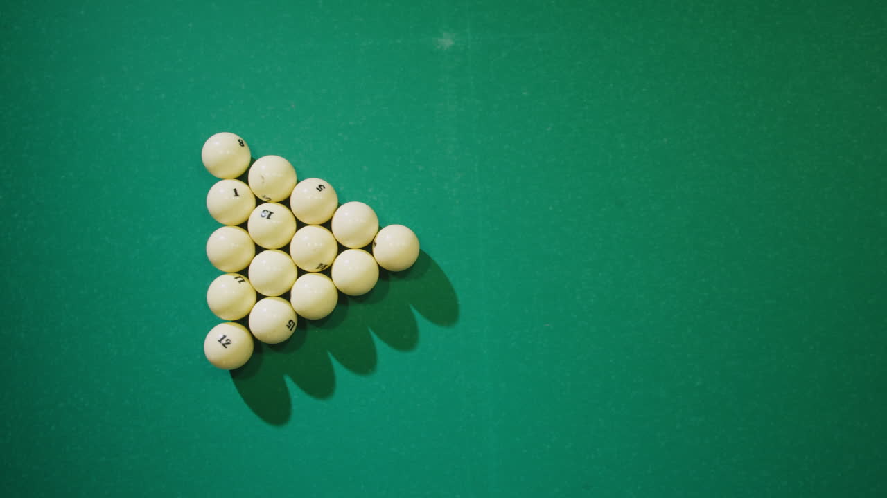 Breaking white pool balls top view on green billiards table for start to play. Russian biliard game, Russian pyramid. Billiard balls with numbers on a pool table. Billiards team sport. High quality 4k footage