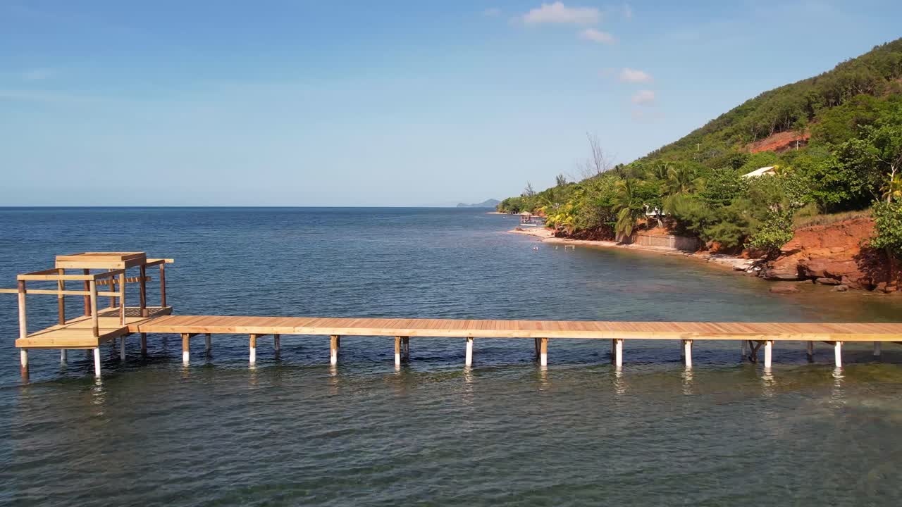 vista aérea de la playa tropical de arena blanca y agua de mar turquesa clara con pequeñas olas y bosque de palmeras, barco, muelle