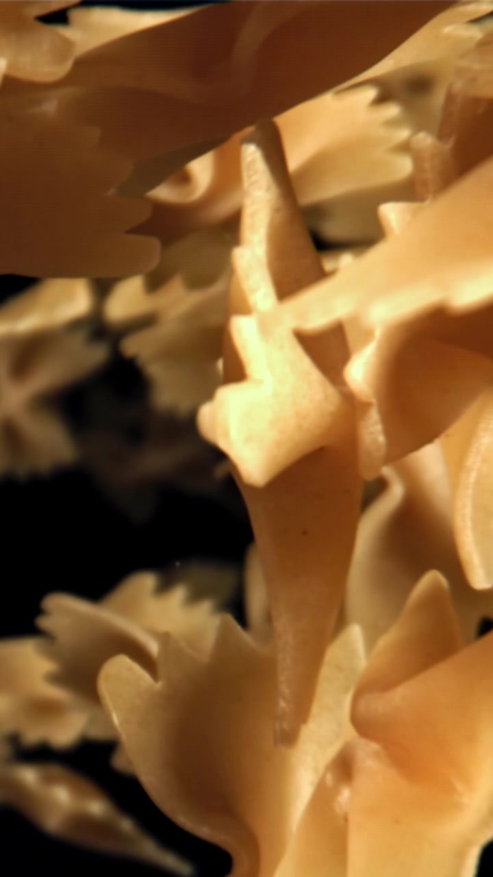 Pasta farfalle che cade al rallentatore su sfondo nero