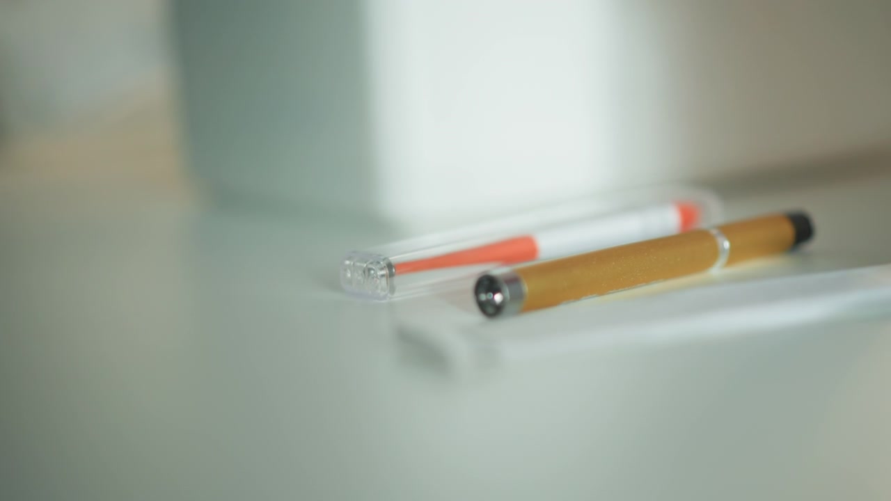 Sterile healthcare pens photographed with softly blurred background elements. Detailed view of medical pens on glossy surface with sterile environment and blurred background images