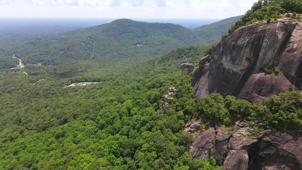 una excelente toma aérea de una bandera americana solitaria plantada en chimney rock carolina del norte