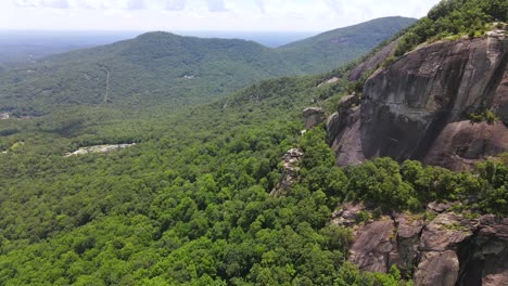 una excelente toma aérea de una bandera americana solitaria plantada en chimney rock carolina del norte