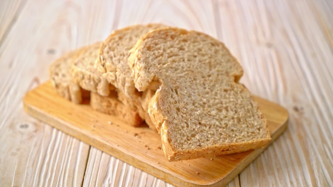 нарезанный цельнозерновой хлеб на деревянном столе