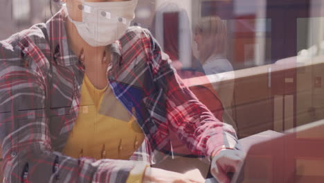 woman wearing face mask using laptop against student using college locker