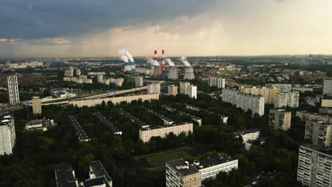 Aerial-view-of-a-power-plant,-a-neighborhood-and-the-Bublik-Circular-House,-dramatic-sunset-in-Moscow,-Russia