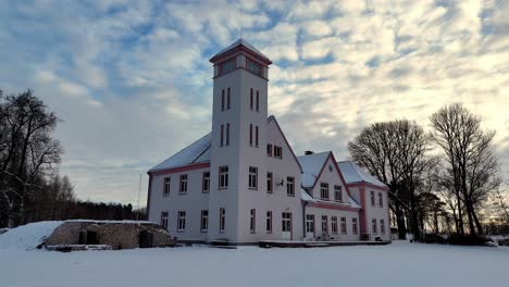 un gran edificio blanco con un techo rojo y una torre del reloj