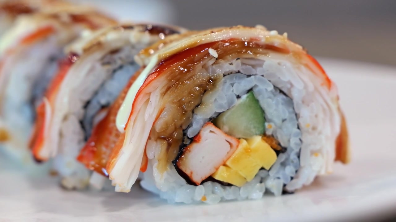 Japansk sushirulle med fisk og skaldyr, avocado og ris, nærbillede der vækker appetitten