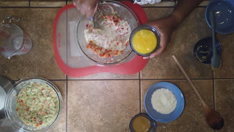 stirring milk and eggs into a traditional meatloaf recipe - top-down view