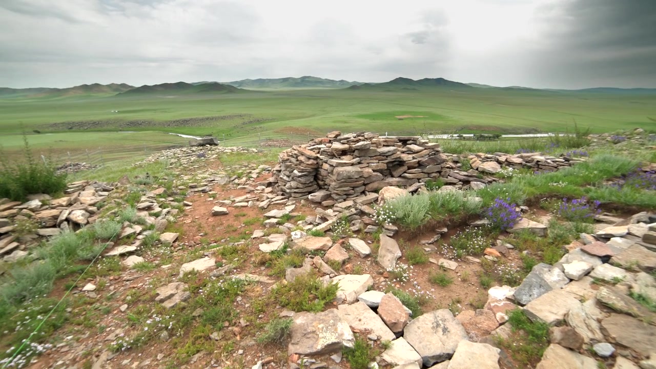 Gamle steinruiner med utsikt over en vidstrakt grønn mongolsk steppe