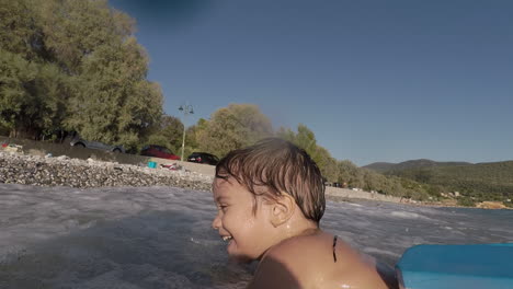 footage of two years old boy, playing with waves at santova beach, kalamata, greece