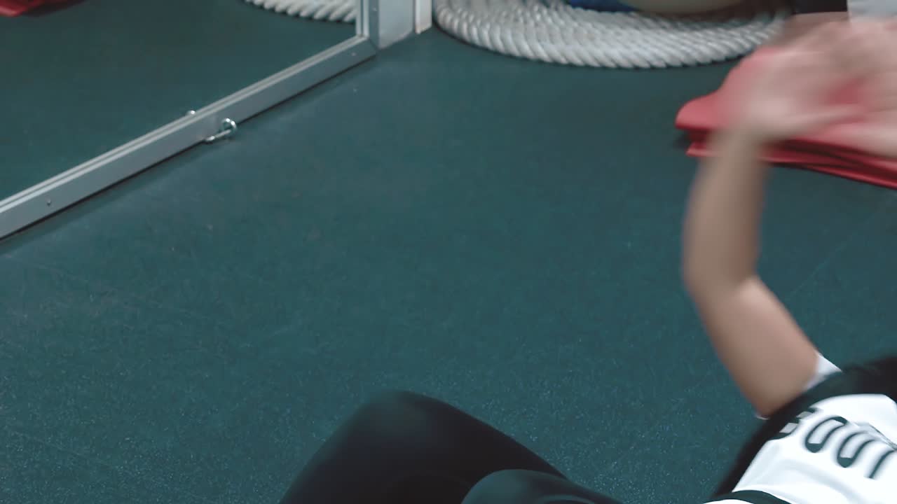 체육관에서 아름다운 젊은 소녀는 카레메타에 누워 있는 기자의 근육을  ⁇ 프합니다.