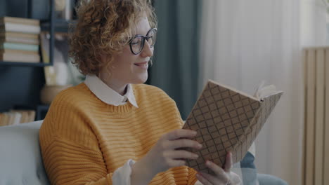 mujer leyendo un libro en un sofá