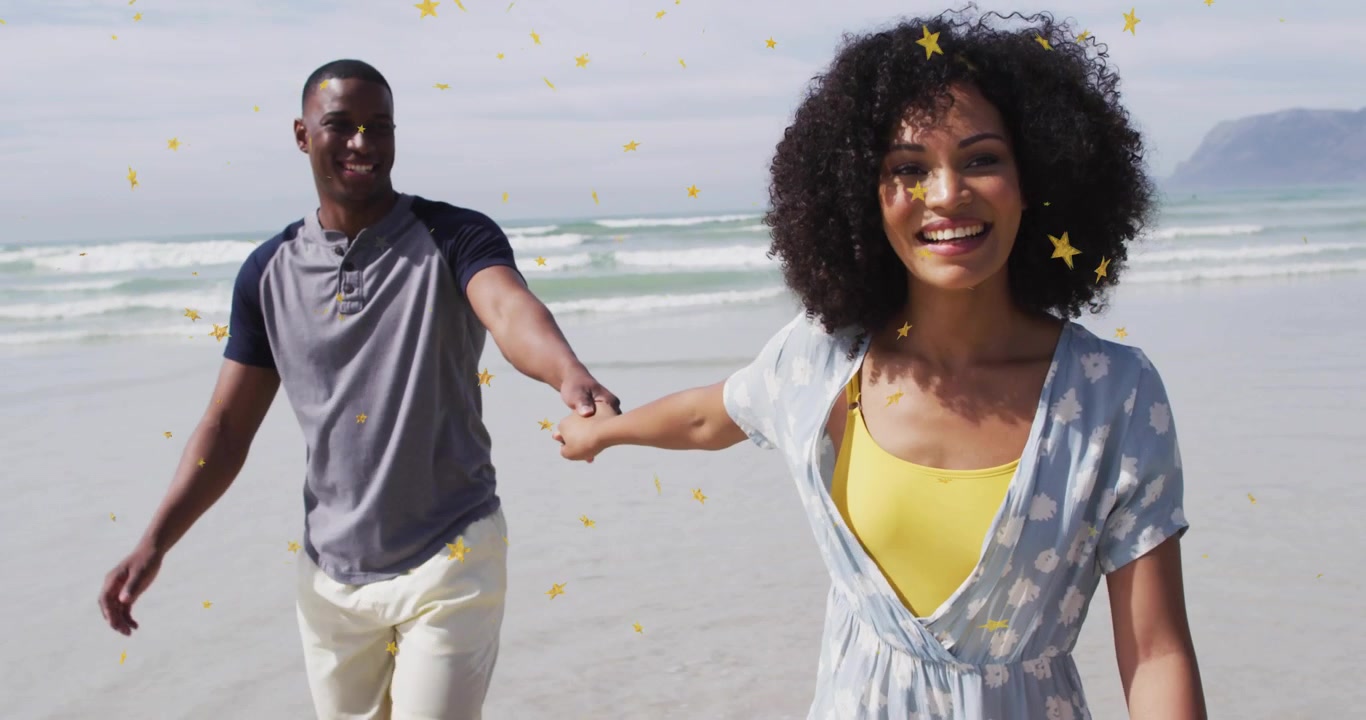 Couple se tenant la main commençant à marcher vers la caméra sur la plage, des étoiles jaunes passant devant ou derrière pour des publicités