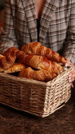 woman holding a basket of croissants