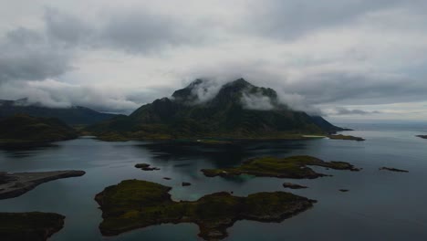 lofoten islands, norway. rugged coast, green mountain peaks, clouds and deep blue sea. aerial drone