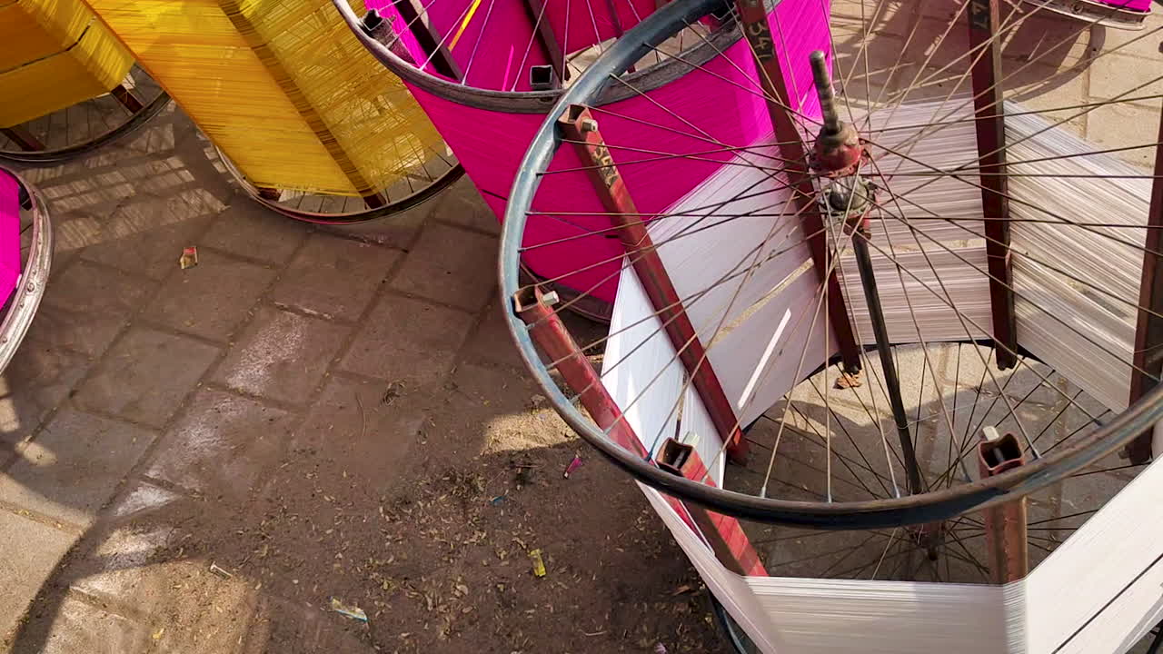 Bobinas de linha de pipa preparadas para o festival de pipas na Índia, barbantes de algodão coloridos enrolados em estruturas de metal, preparação para celebração tradicional, plano de fundo de artesanato cultural colorido