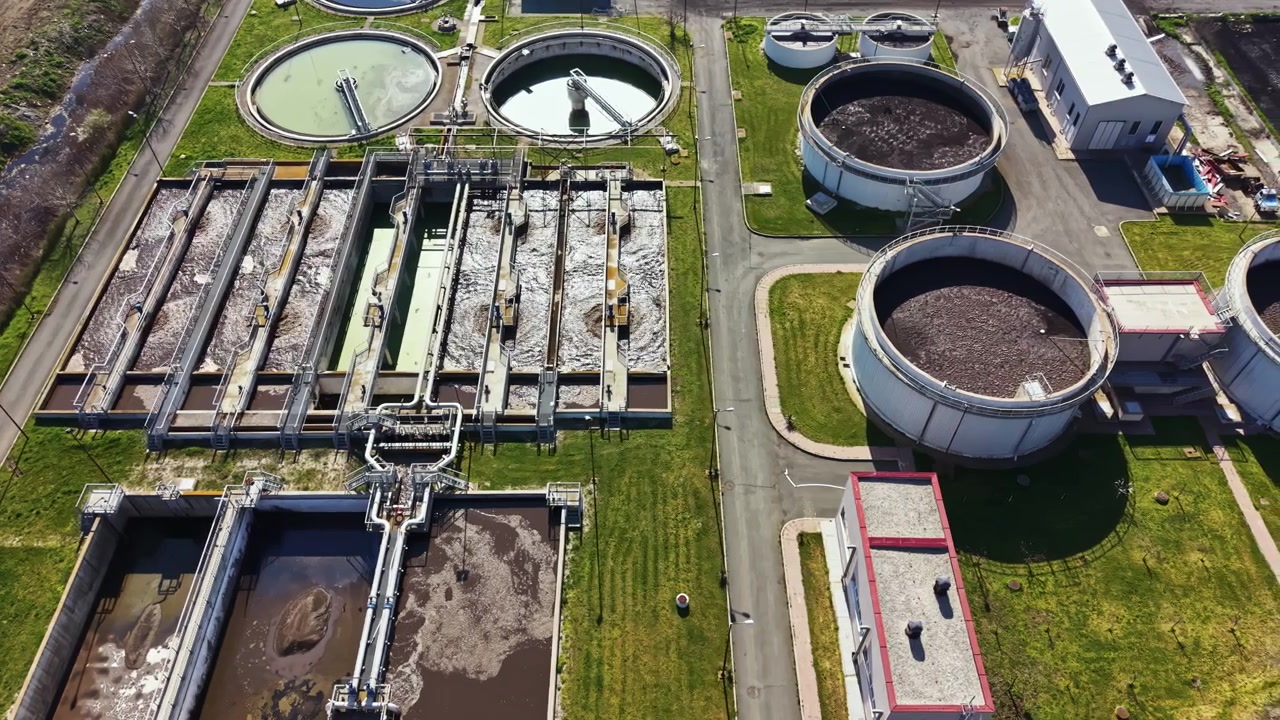 Water treatment facility located in an urban area operates various equipment and processes to clean and treat wastewater during a bright day