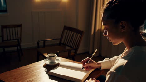 woman writing at a table with a view