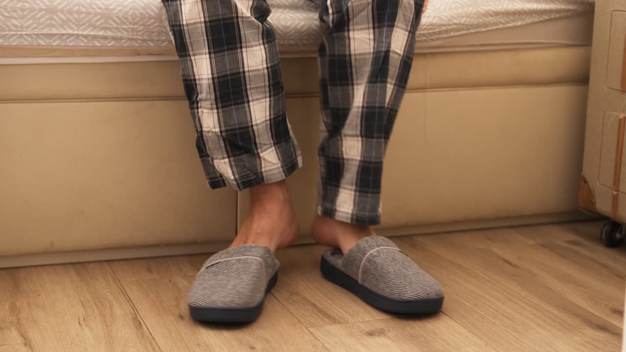 Person putting on slippers when getting out of bed in pyjamas