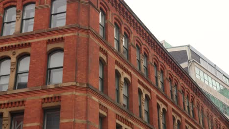 Vista-De-ángulo-Bajo-De-Un-Edificio-Arquitectónico-De-Ladrillo-En-Una-Ciudad-Industrial-En-Una-Calle-De-Manchester,-Inglaterra