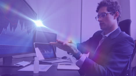 video compuesto digital de puntos de luz contra un hombre caucásico usando desinfectante de manos en la oficina