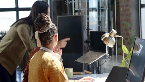 diverse female team collaborating on coding project in modern office, discussing ideas