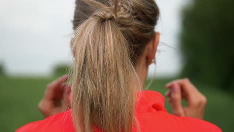 female runner inserting earphone before virtual coaching fitness workout