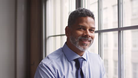 Middle-aged-black-businessman-turns-and-smiles-to-camera