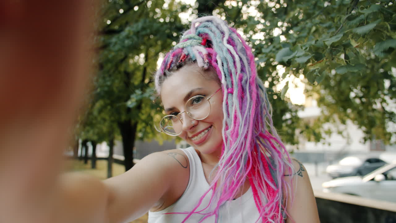 una mujer joven tomando una selfie en un parque.