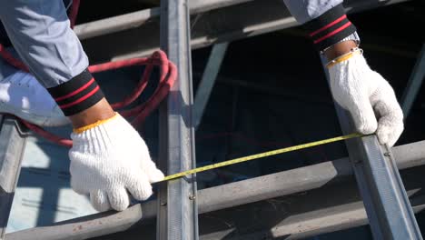 asian worker doing roof tiles installation, cutting, measuring process, close up