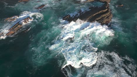 gran ola del océano atlántico rompiendo un acantilado rocoso en la costa de portugal, vista de arriba hacia abajo del dron