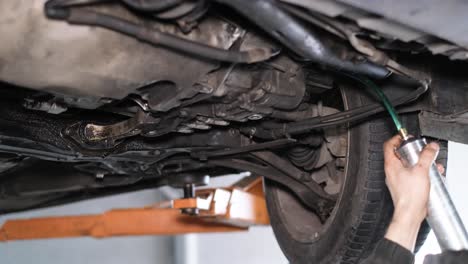 mechanic working on the undercarriage of a car on a lift