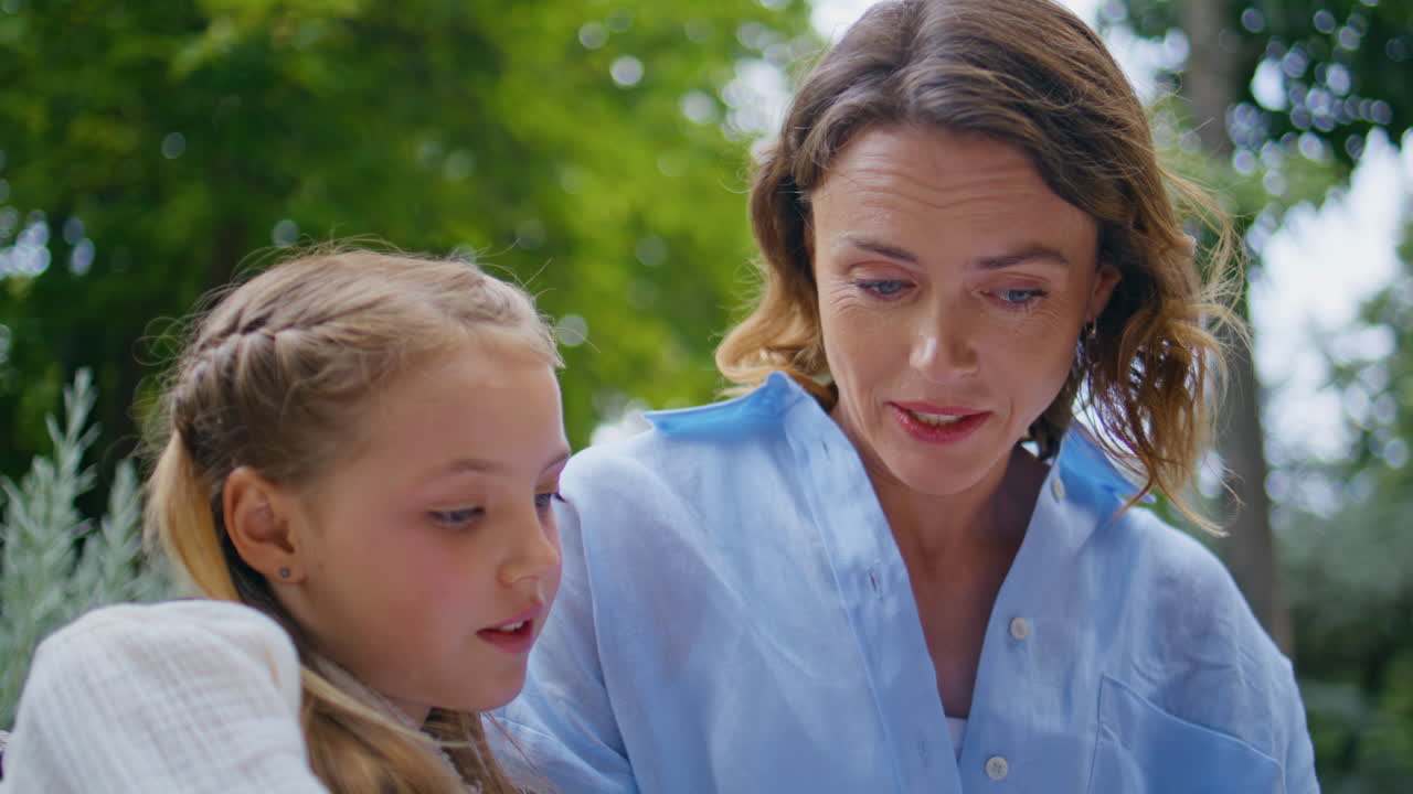 Mom child communicating nature closeup. Woman adorable little girl studying