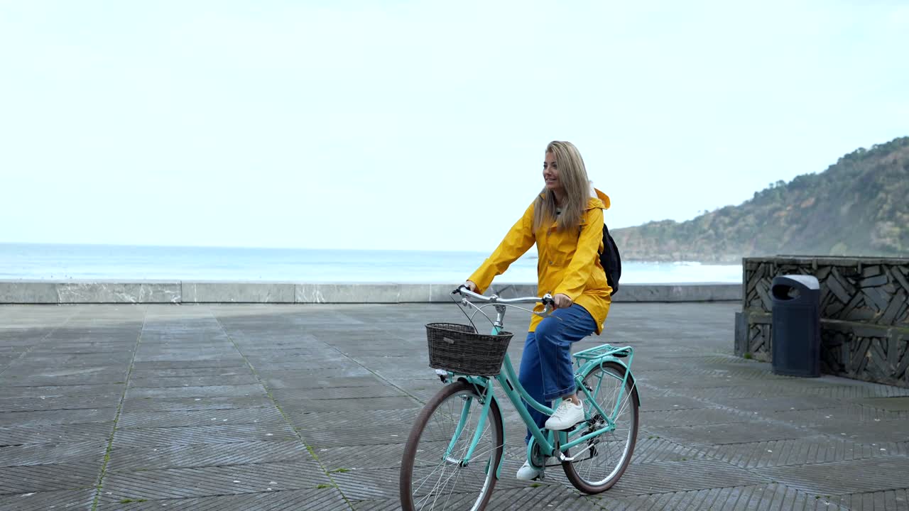 A woman riding a bicycle by the sea